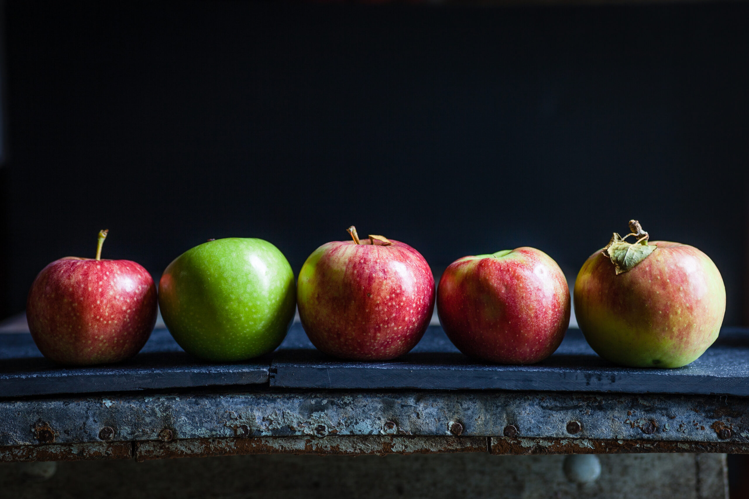 Apples lined up on a table.